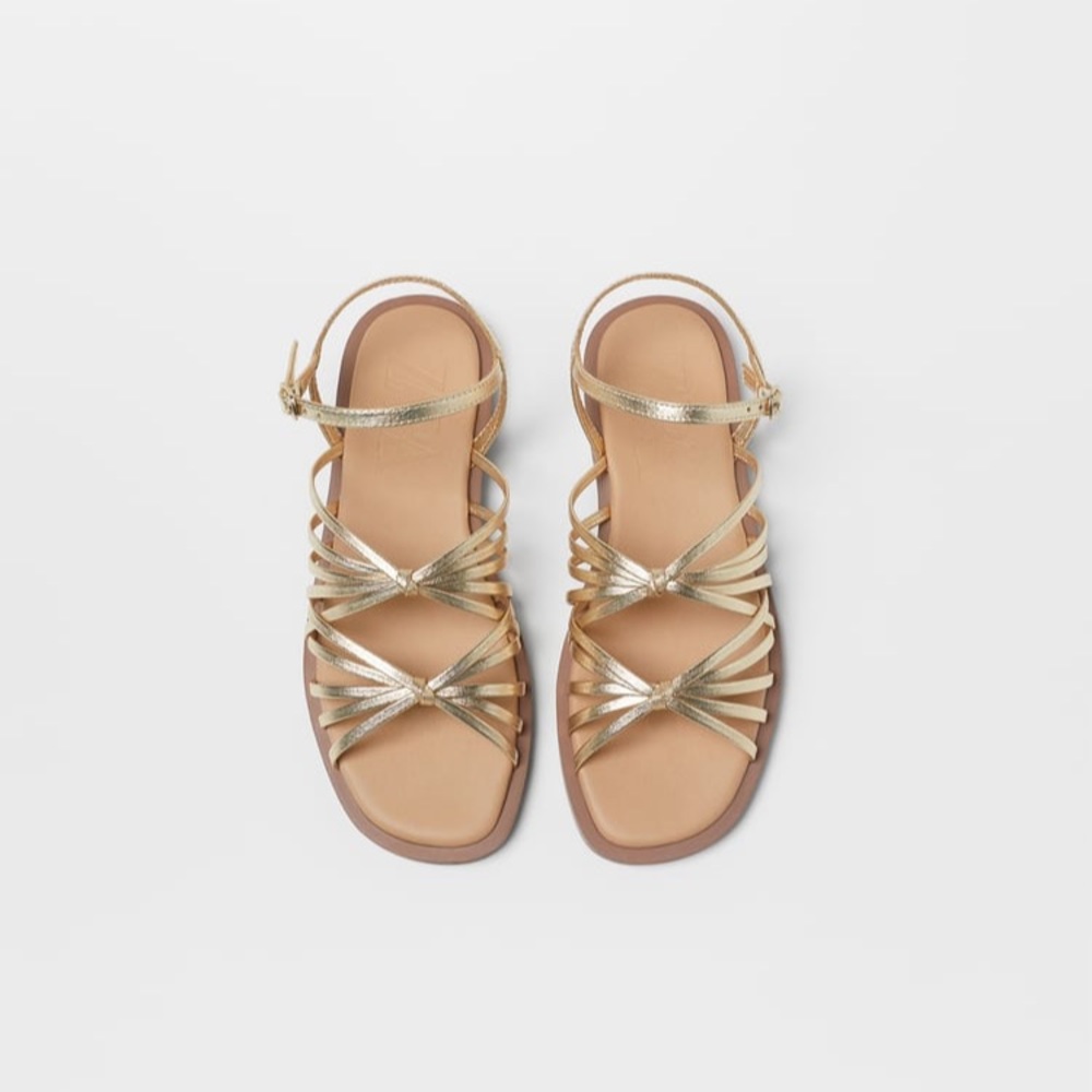 SANDALS WITH GOLD COLORED STRAPS AND KNOTTED.